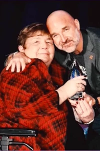 Rosie accepts an award and hugs a man who has presented the prize 